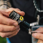 Person holding a bottle of Loon Lochsa Premium Gel Floatant  while working on a fly fishing fly.