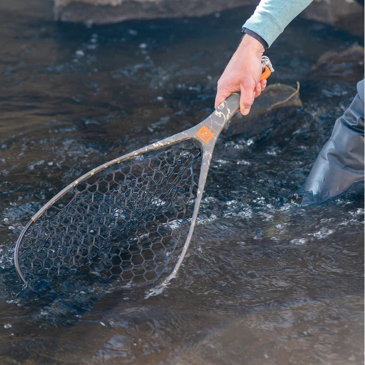 Person holding a fishing net over water
