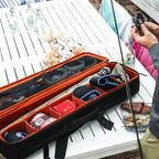 Fishing tackle box with fishing gear on a table outdoors