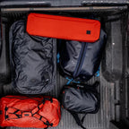 Black and red Simms Tailwind Rod & Reel Vault in a vehicle's cargo area