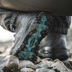Close-up of a Simms WOMEN's Freestone Wading Boot - Rubber Soles with a textured sole on a rocky ground