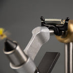 A black PEAK Material Clip on a vise