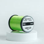 Chartreuse spool of fly-tying thread with 'veevus' branding on a white background