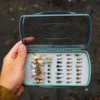 Open Fishpond Tacky Pescador Fly Box - Medium - Clear -Dynamic Foam box with various flies held by a hand against a natural background.