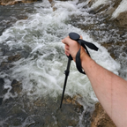Hand holding a Teton Locking Wading Staff w/Adjustable Length over a rushing river