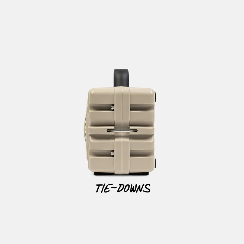 Tan Turtlebox Cub speaker with black tie-downs on a white background.