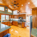 Modern kitchen with wooden cabinets, stainless steel appliances, and a island.