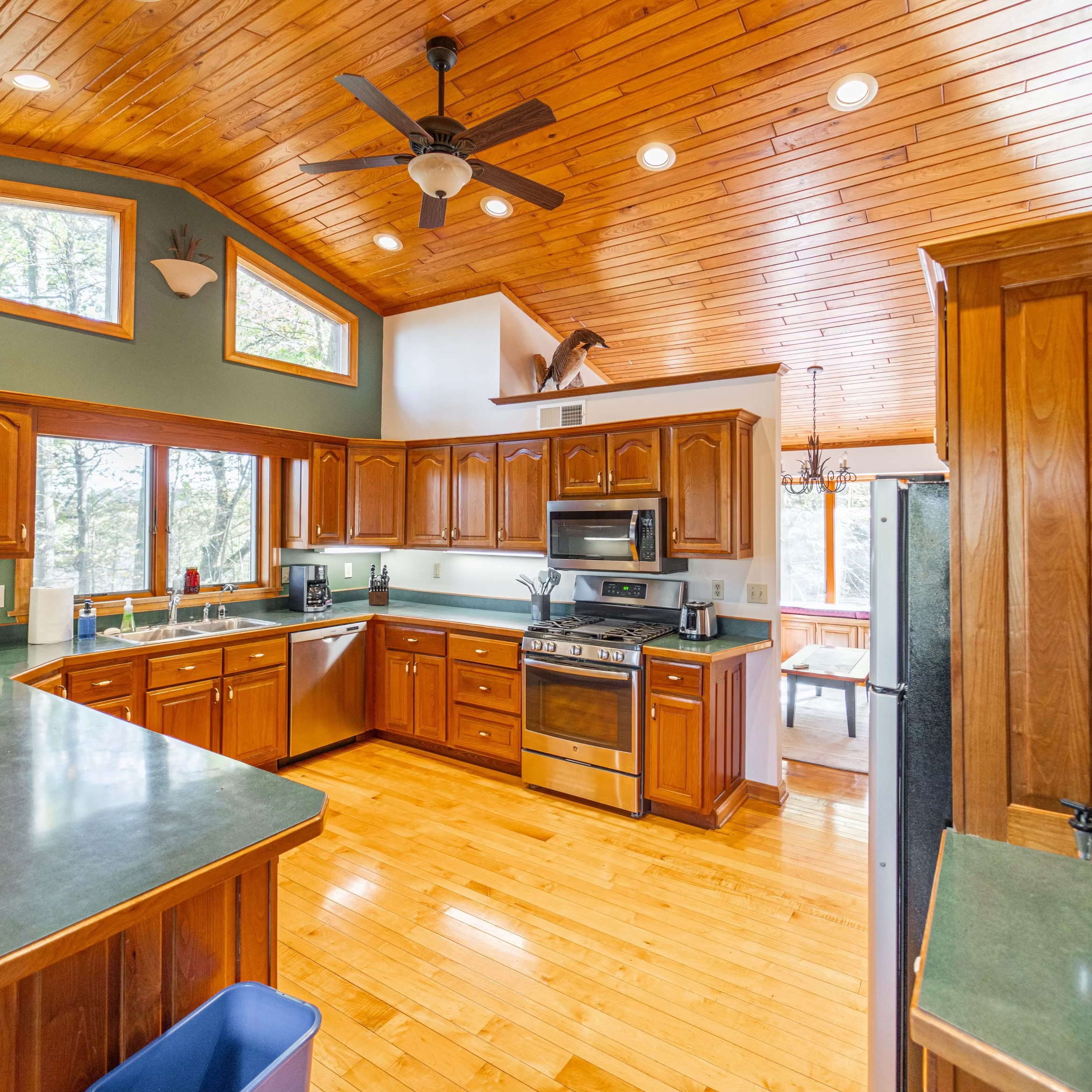 Modern kitchen with wooden cabinets, stainless steel appliances, and a island.