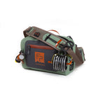 A green Fishpond Thunderhead Small Submersible Lumbar pack with a brown shoulder strap and zippered closures, featuring a logo on the front.