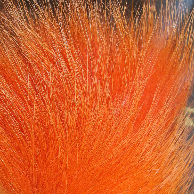 A close-up of a bundle of orange, Hareline Arctic Fox Hair for fly tying, commonly used in crafting fishing flies.