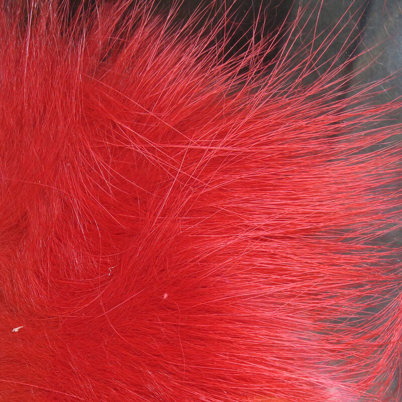 A close-up of a bundle of red, Hareline Arctic Fox Hair for fly tying, commonly used in crafting fishing flies.
