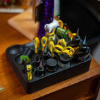 Fly tying tool Loon Bench Boss on a black stand with yellow tools on a wooden surface.