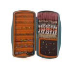 Open fishing fly case with various flies on a white background