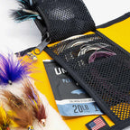 Fishing lures and Fishing lure Yakoda STS Stash with Umpqua branding held by a person outdoors.  