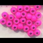 Pink Hareline Dazzle Brass Beads on a light pink background