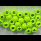 Green Hareline Dazzle Brass Beads with holes on a light gray background