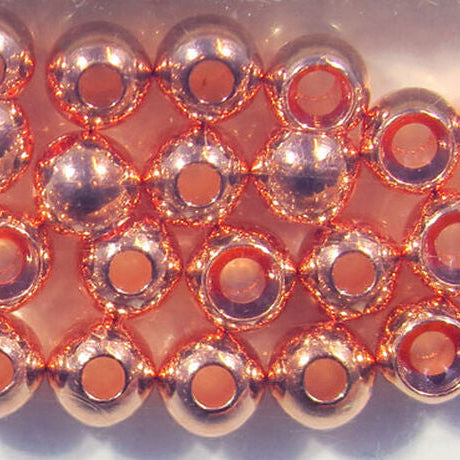Close-up of copper beads arranged in a grid pattern on a white background