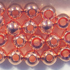 Close-up of copper beads arranged in a grid pattern on a white background