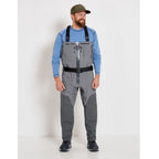 A fisherman with a pair of gray zippered Orvis men's PRO fly-fishing waders with suspenders and boots.