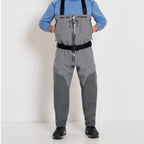 A fisherman with a pair of gray zippered Orvis men's PRO fly-fishing waders with suspenders and boots.