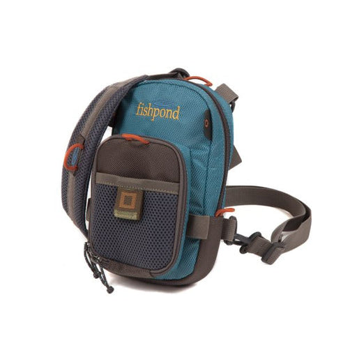 A blue vertical chest pack designed for fishing, with a green and brown color scheme, featuring a main compartment zipper, an interior zippered pocket, and attachment loops.
