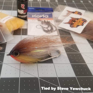 Fly Fishing flyer on a tying mat with various items.