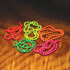 A colorful array of fluorescent bead chains arranged on a wooden surface.