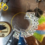 Assorted fishing lures in clear packaging on a metal surface with tools.