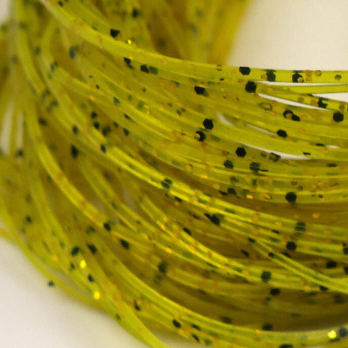 Close-up of yellow Hareline Crazy Legs with black specks on a white background