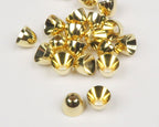 Gold Hareline Brass Cone Heads on a white surface