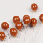 Brown Hareline Epoxy Mono Crab Eyes on sticks with a white background