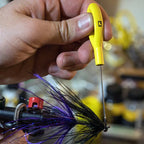 A yellow ergonomic Loon bodkin with a strong Japanese steel needle, used for fly tying.