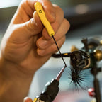 A yellow ergonomic Loon bodkin with a strong Japanese steel needle, used for fly tying.