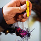 A yellow ergonomic Loon bodkin with a strong Japanese steel needle, used for fly tying.