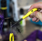 A Loon Ergo Dubbing Brush with a yellow powder-coated handle and black nylon bristles. 