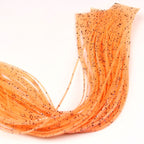 Close-up of orange Hareline Loco Legs on a white surface