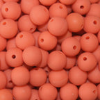 A close-up image of orange round fishing beads with a hole in the center for stringing purposes.