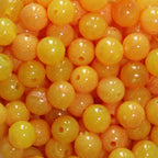 A close-up image of bright yellow round fishing beads with a hole in the center for stringing purposes.