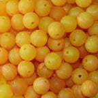 A close-up image of yellow round fishing beads with a hole in the center for stringing purposes.