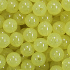 A close-up image of light yellow round fishing beads with a hole in the center for stringing purposes.