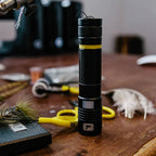 Black UV light with yellow accents on a wooden surface with fly tools in the background