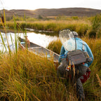Angler wearing a Fishpond Waterdance Pro Guide Pack outdoors