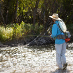 Angler wearing a Fishpond Waterdance Pro Guide Pack outdoors