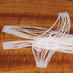 White woven Hareline Crazy Legs on a wooden surface