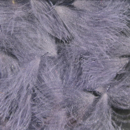 A collection of various sized Hareline CDC Oiler Puffs feathers arranged on a wooden surface.