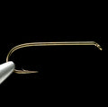 Gold-colored Daiichi 1280 dry fly fishing hook on a black background