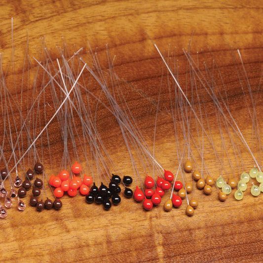 Set of Hareline Epoxy Mono Crab Eyes with colored beads on a wooden surface