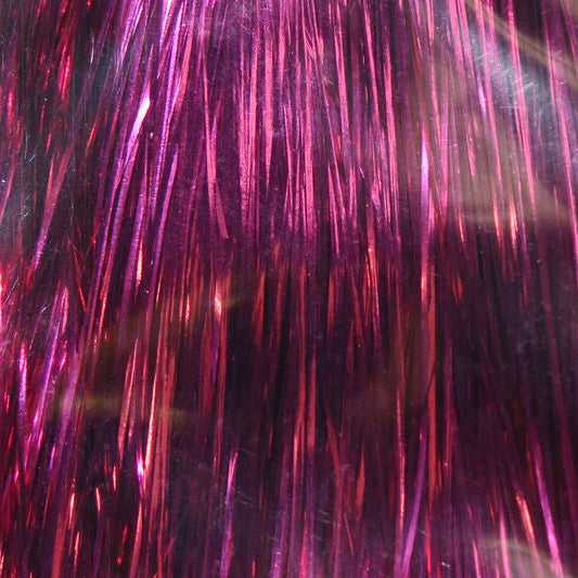 Close-up of pink and red metallic fibers on a dark background