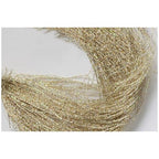 A close-up of Flashabou weave, showing a detailed pattern of gold, silver, and bronze colored strands.