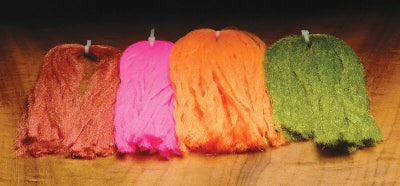 Four colorful Hareline McFLYLON on a wooden surface